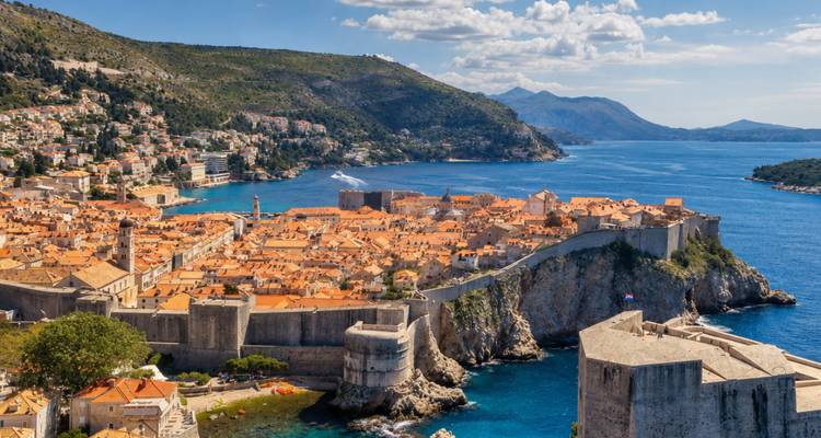 Ikonische befestigte Stadtmauern und Terrakottadächer von Dubrovnik, die sich in die tiefblaue Adria erstrecken.