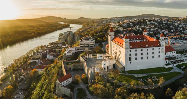 Vue aérienne au coucher du soleil du château de Bratislava dominant l'horizon le long du Danube.