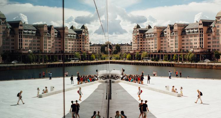 La place du Opéra moderne d'Oslo reflétée dans le verre avec des visiteurs marchant sur le toit en marbre blanc