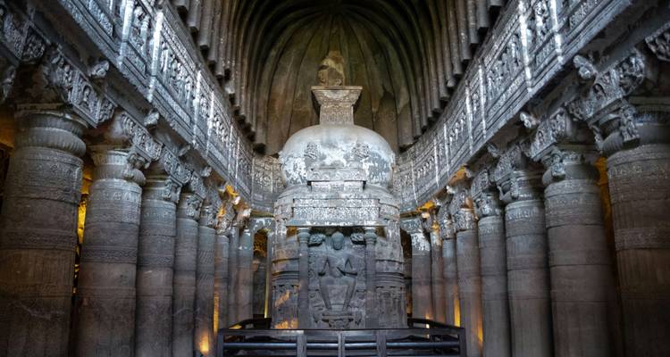 Interieur van een prachtig uitgewerkte chaitya hal met stupa en stenen pilaren zacht verlicht