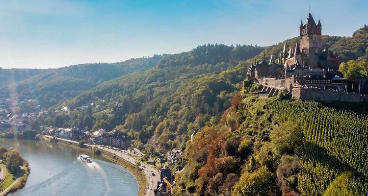 Luftaufnahme der Reichsburg Cochem, die sich oberhalb des mäandrierenden Moselflusses und der weinbestockten Hügel erhebt