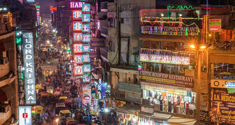 Lebendige Nachtszene einer belebten indischen Marktstraße, beleuchtet durch Neonleuchten und reges Verkehrsaufkommen
