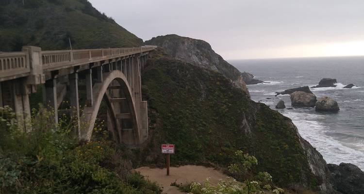 Pont en béton voûté emblématique enjambant une falaise rocheuse escarpée au-dessus de l'océan
