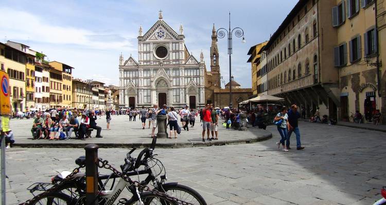 Piazza Santa Croce animée à Florence avec la façade de la basilique, des cyclistes et des touristes