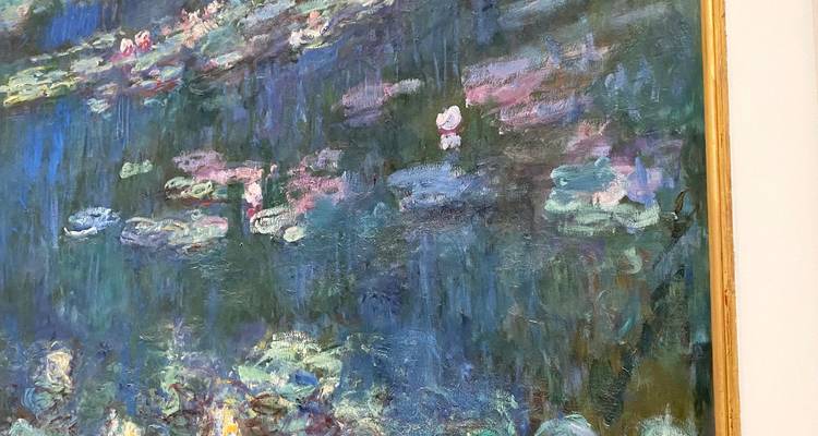 Gros plan sur le tableau Les Nymphéas de Monet révélant des coups de pinceau texturés en bleus, roses et verts.