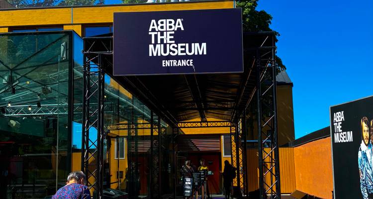 Auvent d'entrée du musée ABBA avec des visiteurs attendant à l'extérieur.