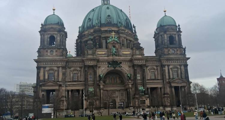 La Cathédrale de Berlin avec son dôme vert domine la scène alors que les visiteurs se promènent sur la pelouse devant.