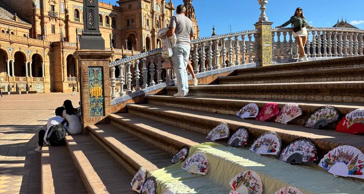 Marches en pierre à la Plaza de España avec des éventails à main colorés exposés et des visiteurs en exploration.