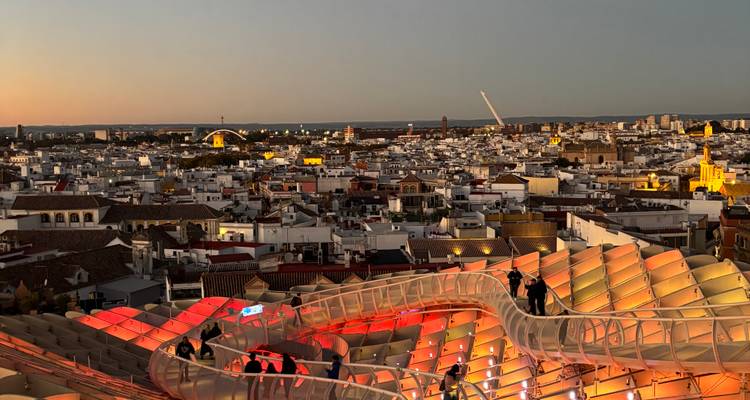 Vue spectaculaire du coucher de soleil sur l'horizon de Séville avec la promenade illuminée de Metropol Parasol en avant-plan.