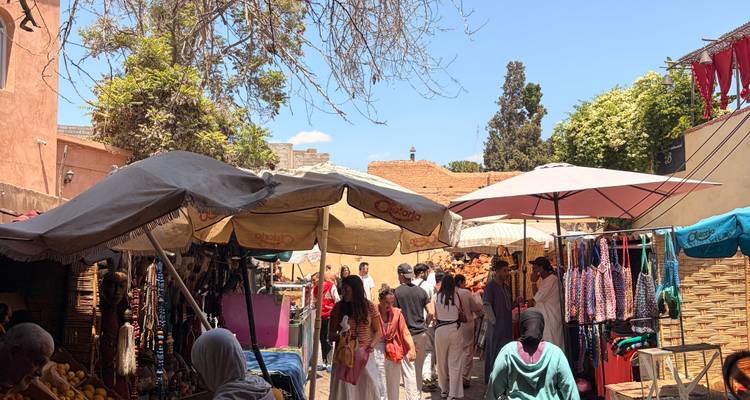 Mercado callejero abarrotado con paraguas, puestos y luz solar brillante filtrándose