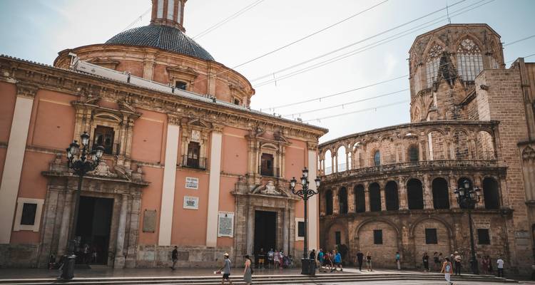 Basilique historique et section de cathédrale ronde sous une lumière douce avec des visiteurs marchant sur la plaza.