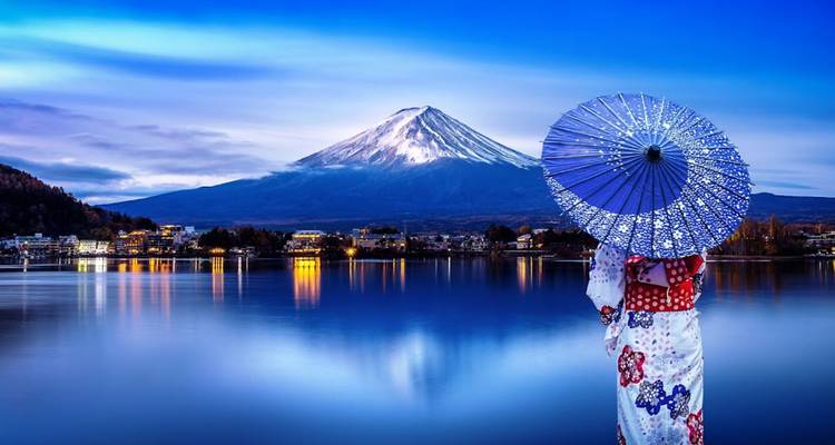 Une femme vêtue d'un kimono tenant un parasol contemple un lac tranquille en direction du Mont Fuji enneigé au crépuscule.