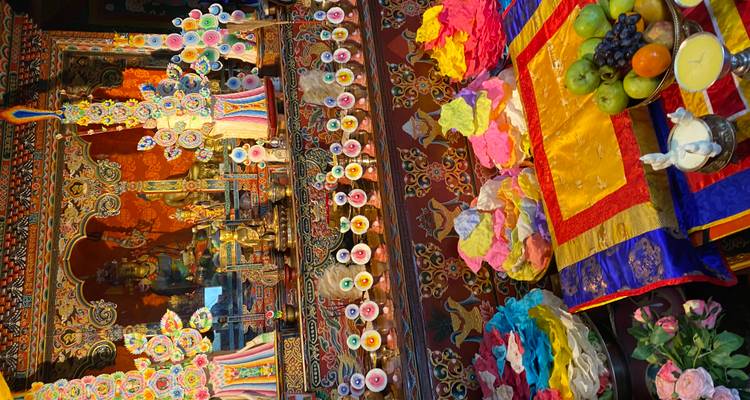 Autel rituel coloré avec des décorations ornées, des offrandes de fruits et des lampes à beurre à l'intérieur d'un temple bhoutanais