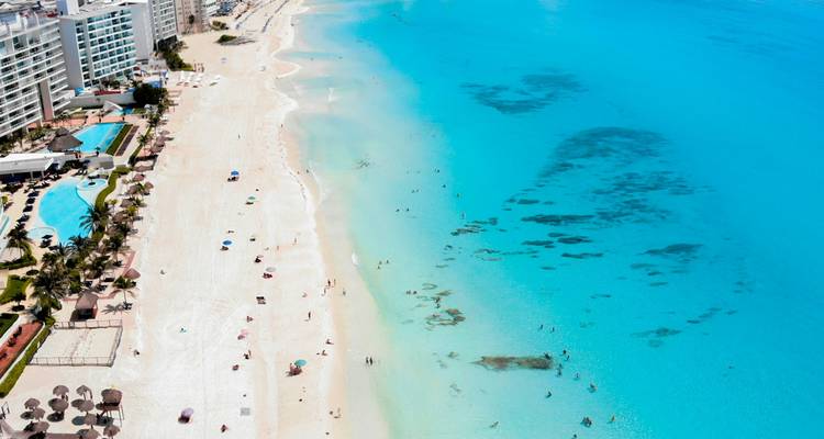 Vue aérienne du littoral aux plages blanches de Cancun, de la mer turquoise et des hôtels de villégiature s'étendant le long du rivage.