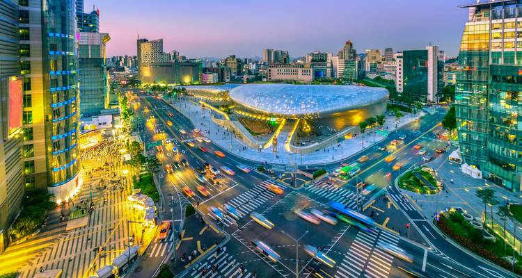 Paysage urbain de Séoul au crépuscule avec la futuriste Dongdaemun Design Plaza illuminée au milieu des traînées de circulation à une vaste intersection.