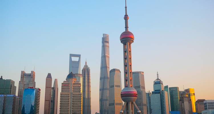 Skyline de Shanghai à l'heure dorée mettant en vedette la Tour de la Perle orientale et les gratte-ciel environnants dans une lumière chaleureuse.