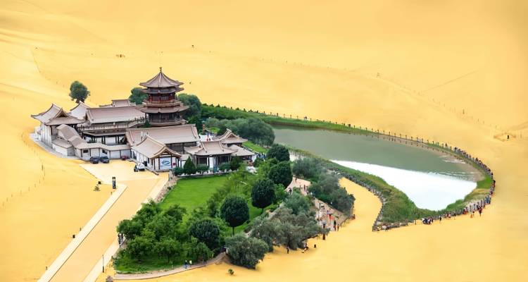 Vista aérea del oasis del Lago Creciente y complejo de templos rodeado por enormes dunas de arena dorada del desierto.