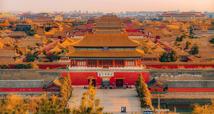 Vista de la hora dorada sobre la Ciudad Prohibida de Beijing con capas de techos ornamentados brillando en luz cálida.