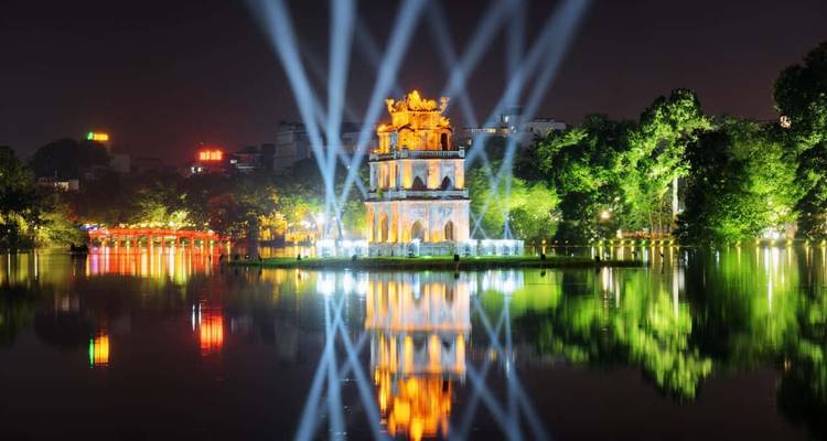 Vue nocturne de la Tour de la Tortue sur le lac Hoan Kiem illuminée par des faisceaux laser à Hanoi.