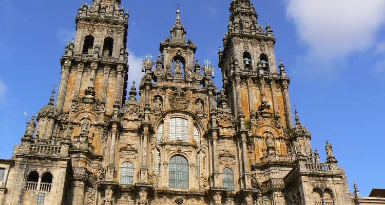Les tours baroques et la façade ornée de la Cathédrale de Santiago de Compostela sur un ciel bleu éclatant