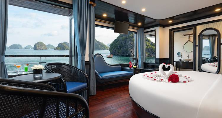 Cabine de croisière luxueuse avec lit rond et grandes baies vitrées surplombant les îles karstiques de la baie d'Halong
