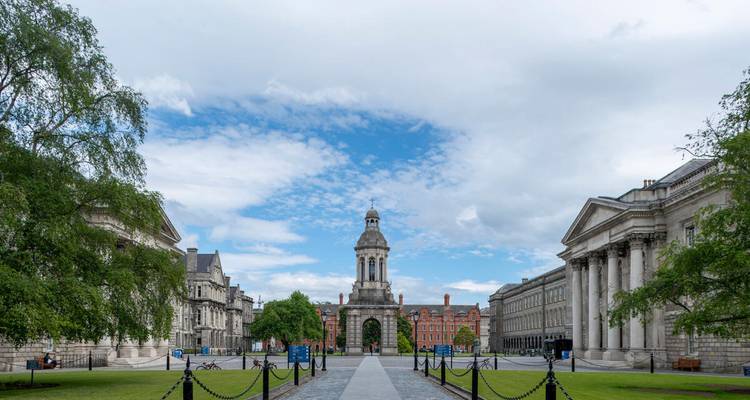 Vue symétrique de la cour principale du Trinity College Dublin avec le campanile emblématique encadré par des bâtiments de style classique