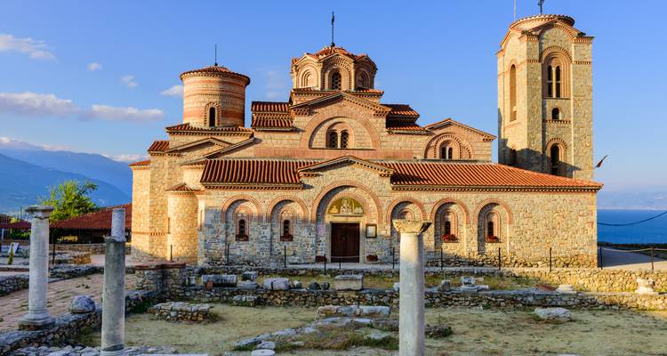 Byzantinisches Steinkloster am Ufer des Ohridsees vor entfernten Bergen im warmen Nachmittagslicht