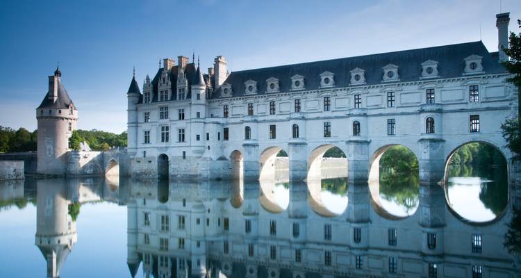 Elegant Renaissance kasteel dat zich uitstrekt over een spiegelende rivier met boogvormige galerijen als bruggen