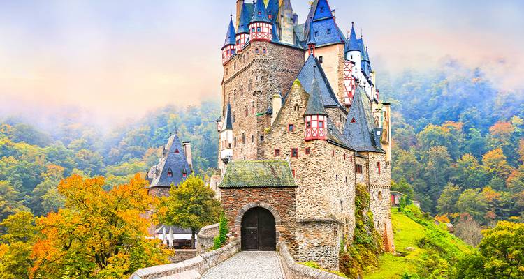 Das märchenhafte Schloss Burg Eltz erhebt sich über den Herbstwald im Morgennebel.