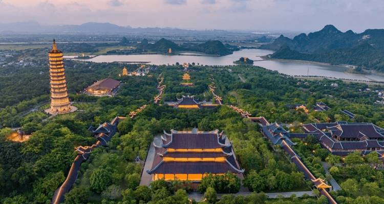 Panorama aérien du complexe de la Pagode de Bai Dinh avec les longs toits du temple, la tour élancée et les montagnes lointaines au crépuscule