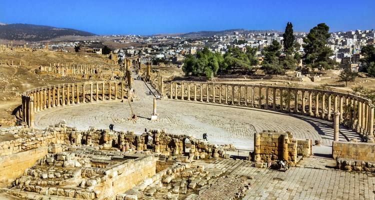Vue panoramique du Forum Ovale de Jerash et du Cardo à colonnes avec des ouvriers effectuant des fouilles parmi les ruines.