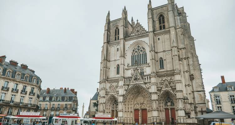 Impressionnante façade gothique de la Cathédrale de Nantes qui domine la place et les bâtiments environnants.