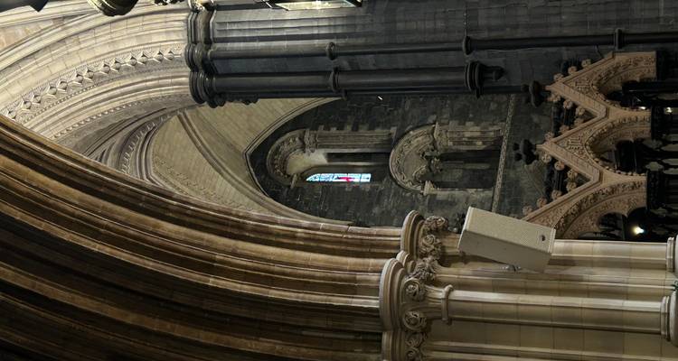 Detail of soaring stone arches and columns inside a gothic cathedral.