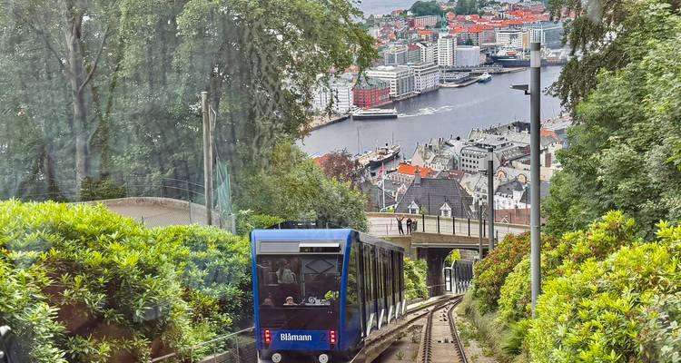 Voiture de funiculaire bleue descendant des rails escarpés avec vue panoramique sur la ville de Bergen et le port en contrebas.