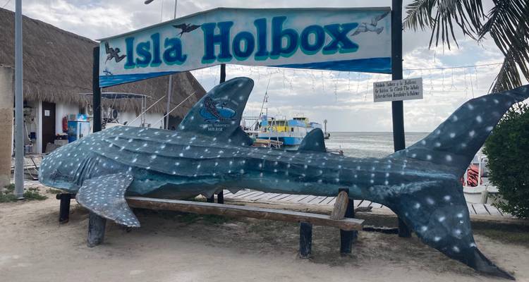 Grand banc en forme de requin-baleine sous un panneau « Isla Holbox » près de la jetée