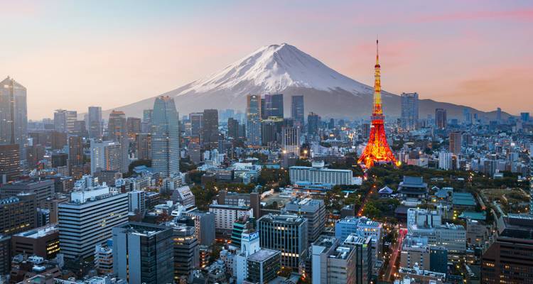 Horizonte de Tokio al atardecer con la Torre de Tokio iluminada recortada contra el cono nevado del Monte Fuji.