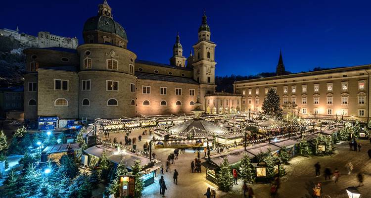 La cathédrale de Salzbourg et la place environnante brillent de lumières festives lors d'un marché de Noël en soirée.