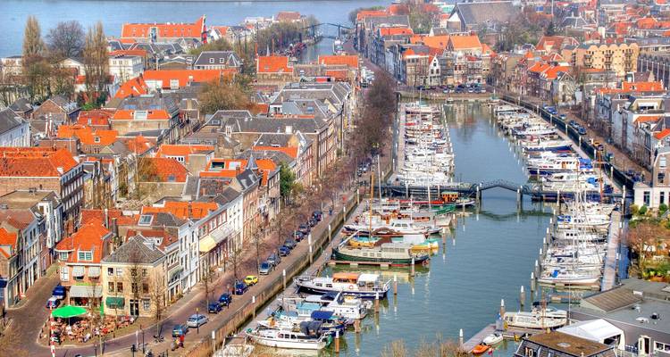 Luchtfoto van Dordrechts historische haven met rode daken en rijen aangemeerde boten.