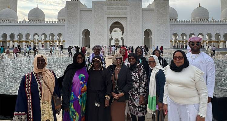 Les visiteurs posent à côté des bassins de réflexion situés devant les arcs en marbre de la Grande Mosquée Sheikh Zayed.