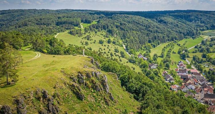 Luchtfoto van groene dalen, beboste heuvels en een monument aan de kliffzijde in de regio Altmühltal.
