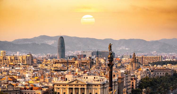 Goldener Sonnenuntergang über der Skyline von Barcelona mit dem Kolumbus-Denkmal und der Torre Glòries.