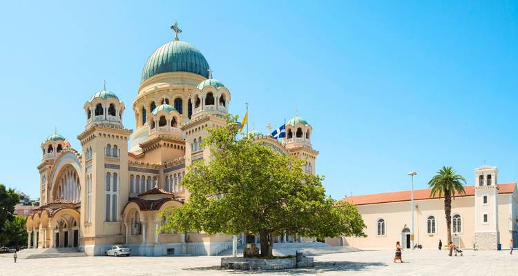 La cathédrale Saint-André à Patras avec ses dômes verts s'élève contre un ciel d'un bleu éclatant.