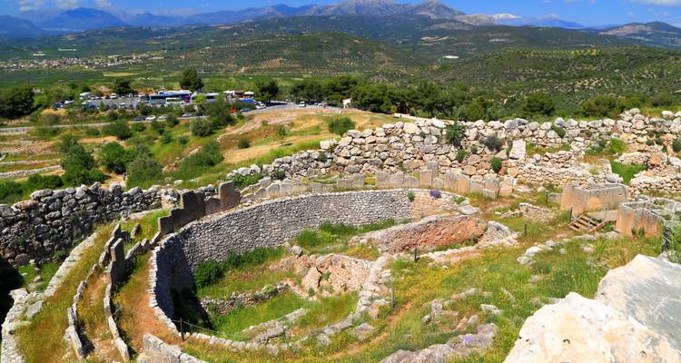 Les vestiges en pierre d'une enceinte royale de tombe circulaire à Mycènes, situés dans une verdoyante vallée.