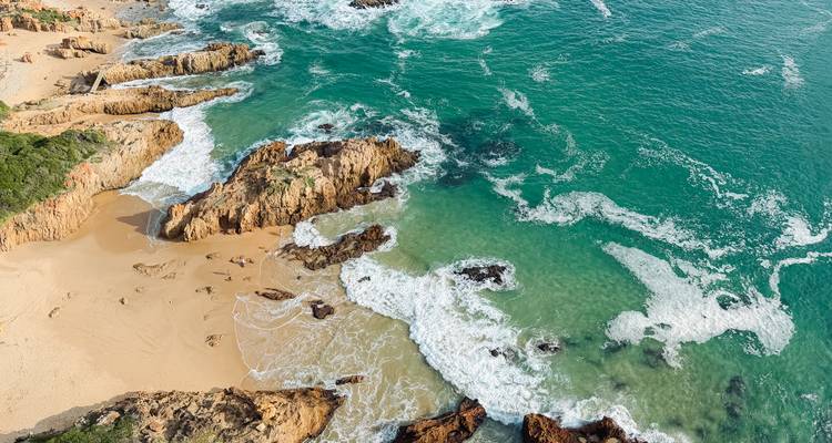 Vue aérienne de la côte escarpée avec des vagues turquoise et une plage dorée dans la région de Tsitsikamma