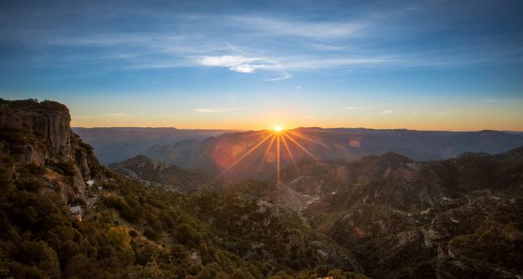 Los rayos del amanecer se abren paso sobre las capas de acantilados de Cobre creando un efecto de estrella arriba del Cañón de Cobre