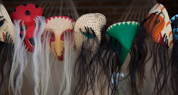 Fila de máscaras tradicionales coloridas con barbas largas de crin de caballo colgando en exhibición