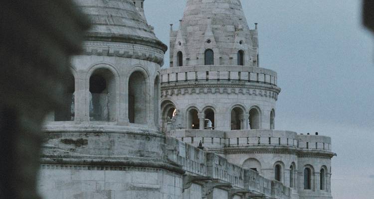Les tourelles de pierre de la Bastion des Pêcheurs s'élevant contre un ciel pâle, capturées dans une lumière douce.