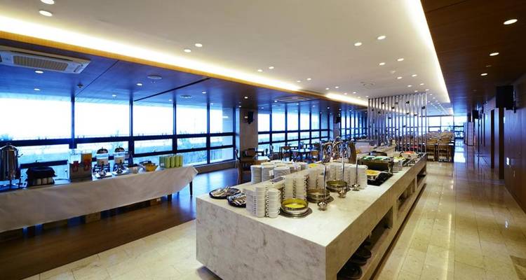 Modernes Buffetrestaurant mit langer Marmorkulisse, ordentlich angeordneten Speisen und Panoramafenstern.
