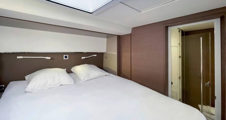 Kompakte Yachtkabine mit ordentlich gemachtem Doppelbett und eigenem Badezimmer mit moderner Ausstattung