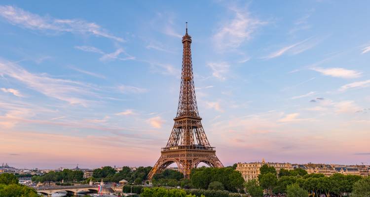 La icónica Torre Eiffel elevándose sobre el horizonte parisino en un atardecer de colores pastel